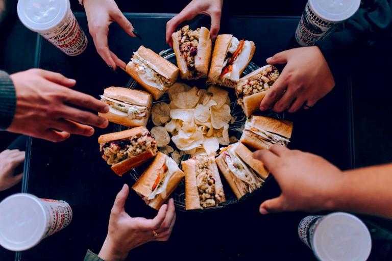 People reaching for Capriotti's sandwiches 